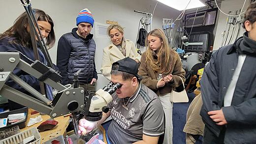 A guest examines a diamond with a jeweler's loupe